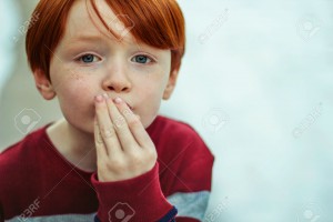 27701906-6-year-old-redheaded-boy-with-his-hand-to-his-mouth-to-blow-a-kiss-Stock-Photo